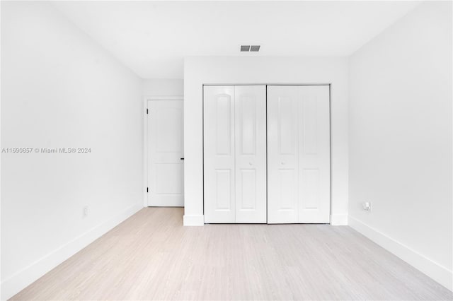 unfurnished bedroom with light hardwood / wood-style floors and a closet