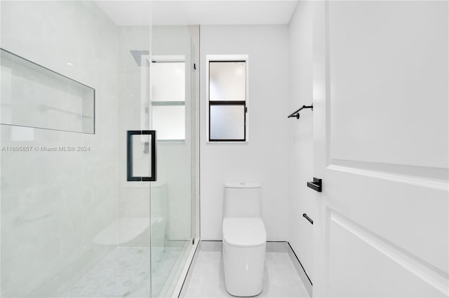 bathroom with toilet, tile patterned floors, and a shower with shower door