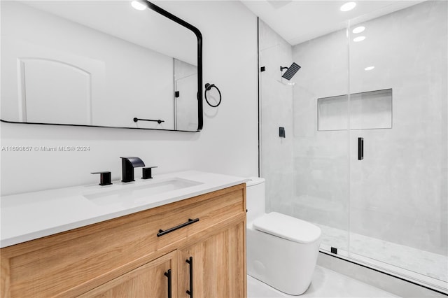 bathroom with a shower with door, vanity, and toilet