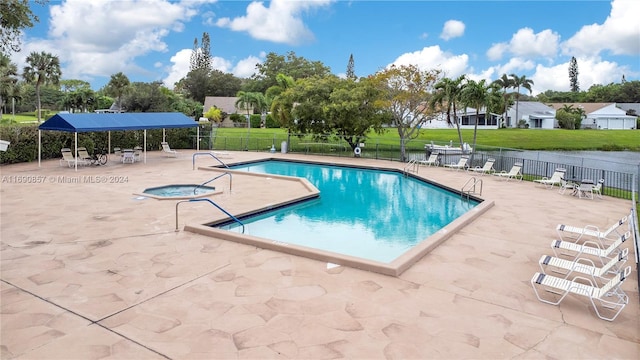 view of swimming pool with a water view, a lawn, and a patio area