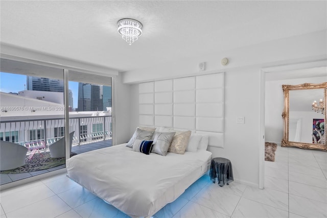 bedroom featuring a textured ceiling, access to outside, a notable chandelier, and multiple windows