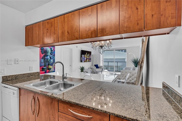 kitchen featuring dishwasher, a notable chandelier, sink, and dark stone counters