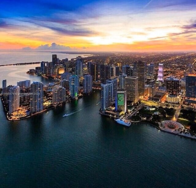 aerial view at dusk featuring a water view