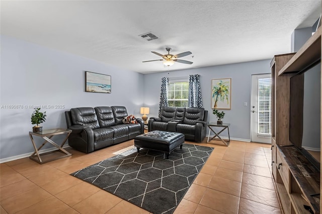 tiled living room featuring ceiling fan, a wealth of natural light, and a textured ceiling