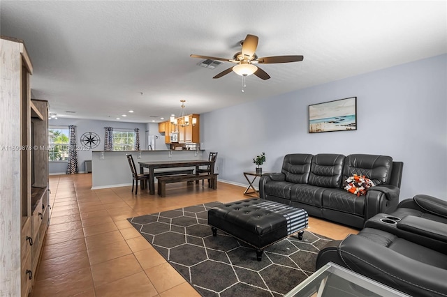 living room featuring ceiling fan with notable chandelier and light tile patterned floors