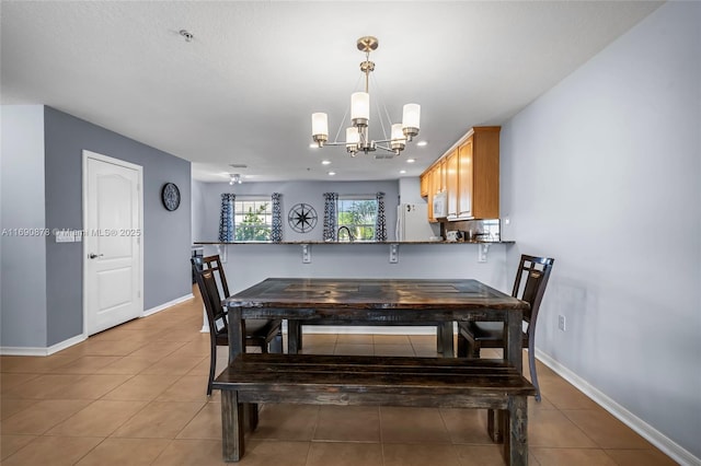 tiled dining room featuring an inviting chandelier