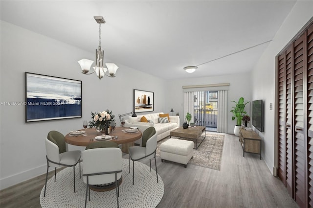 dining room with hardwood / wood-style floors and a notable chandelier