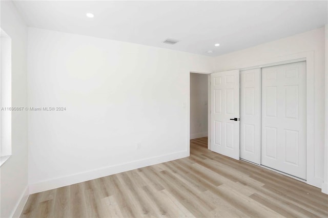 unfurnished bedroom with light hardwood / wood-style floors and a closet