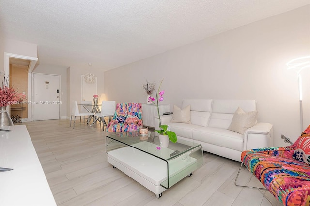 living room featuring light wood-type flooring and a textured ceiling