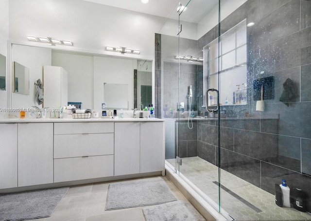 bathroom with walk in shower, vanity, and tile patterned floors