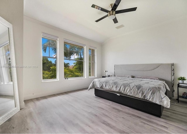 bedroom featuring lofted ceiling, ceiling fan, light wood-type flooring, and crown molding