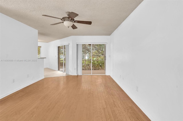 spare room with a textured ceiling, light wood-style flooring, and a ceiling fan