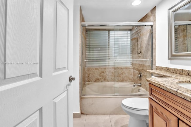 bathroom with combined bath / shower with glass door, vanity, toilet, and tile patterned floors