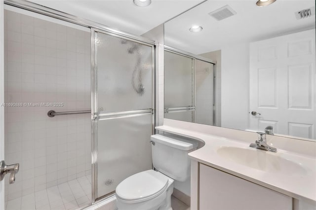 bathroom featuring toilet, a stall shower, vanity, and visible vents