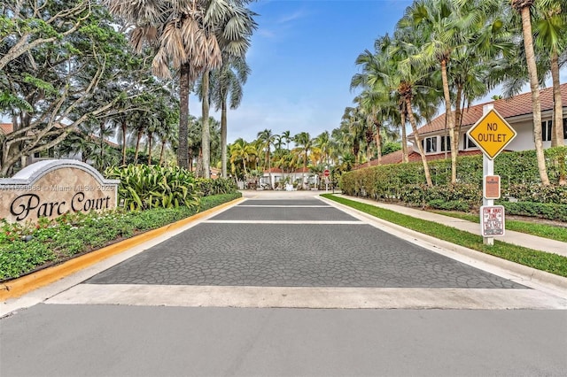 view of street featuring curbs, a gated entry, and traffic signs