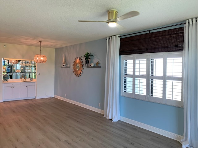 unfurnished dining area with dark hardwood / wood-style flooring, a textured ceiling, and ceiling fan