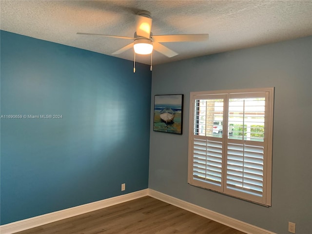 empty room featuring hardwood / wood-style floors, ceiling fan, and a textured ceiling