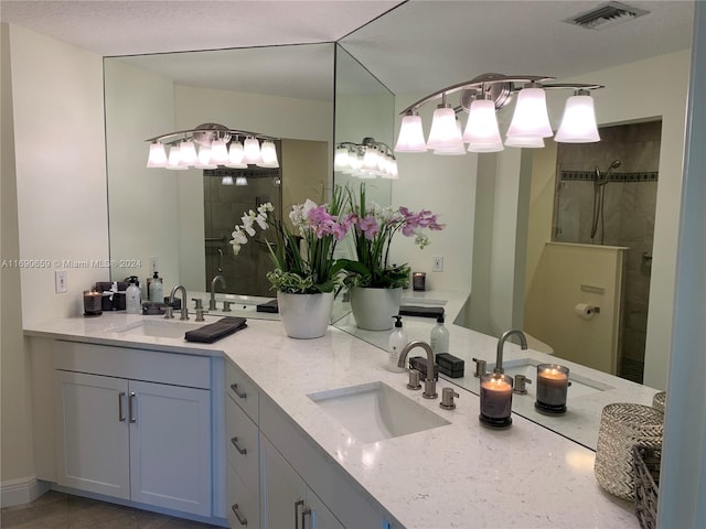 bathroom with vanity and a tile shower