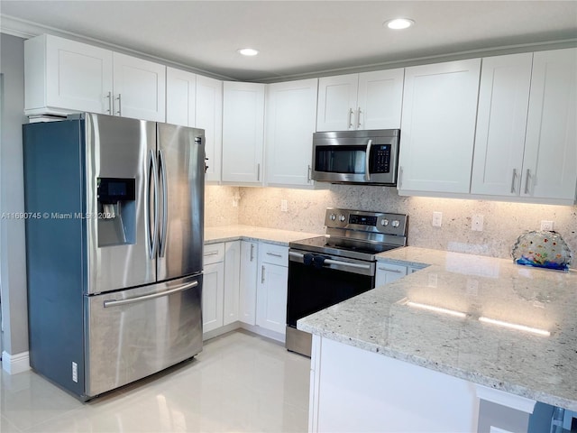 kitchen featuring decorative backsplash, kitchen peninsula, light stone counters, stainless steel appliances, and white cabinetry