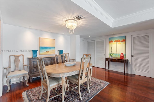 dining space featuring dark hardwood / wood-style flooring, a chandelier, and crown molding