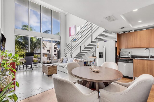 dining area featuring sink and a towering ceiling