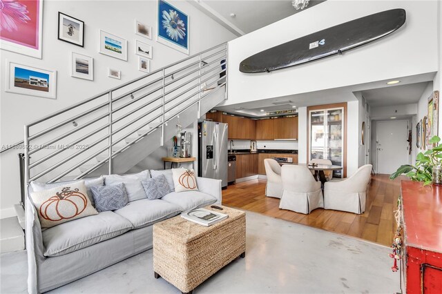 living room featuring a high ceiling and concrete flooring