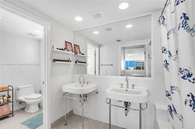 bathroom featuring a shower with shower curtain, sink, toilet, and tile patterned flooring