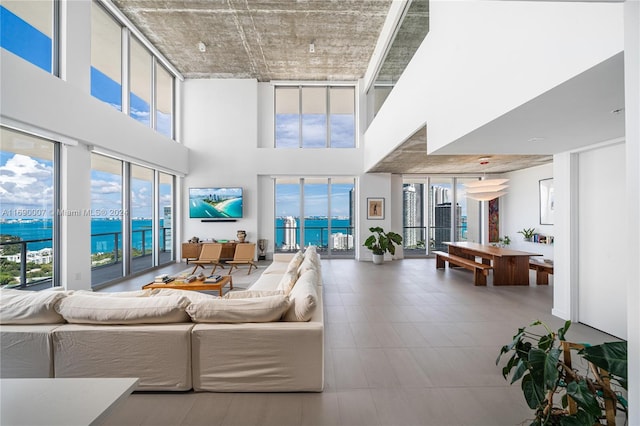 living room with a towering ceiling, plenty of natural light, and a water view