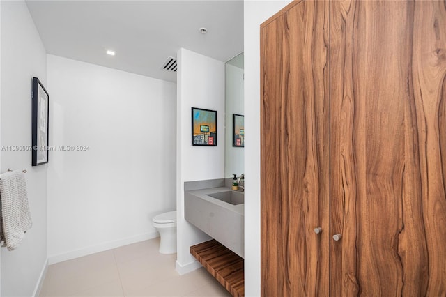 bathroom featuring vanity, tile patterned floors, and toilet