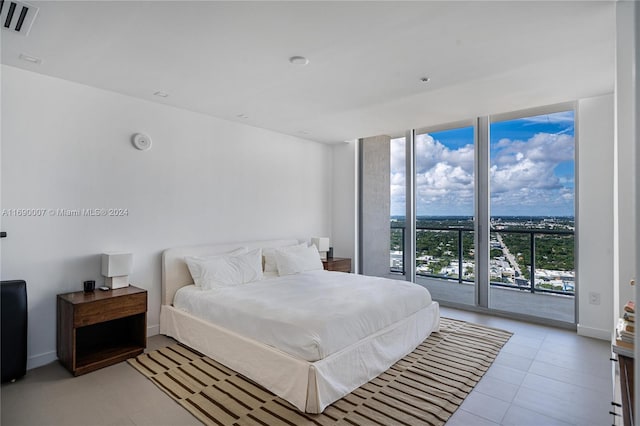 bedroom featuring access to exterior, light tile patterned floors, and floor to ceiling windows