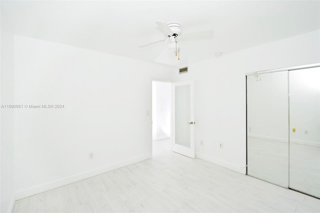 unfurnished bedroom featuring ceiling fan, a closet, and light hardwood / wood-style flooring