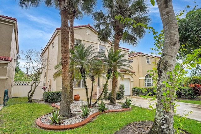 mediterranean / spanish house featuring a garage and a front yard