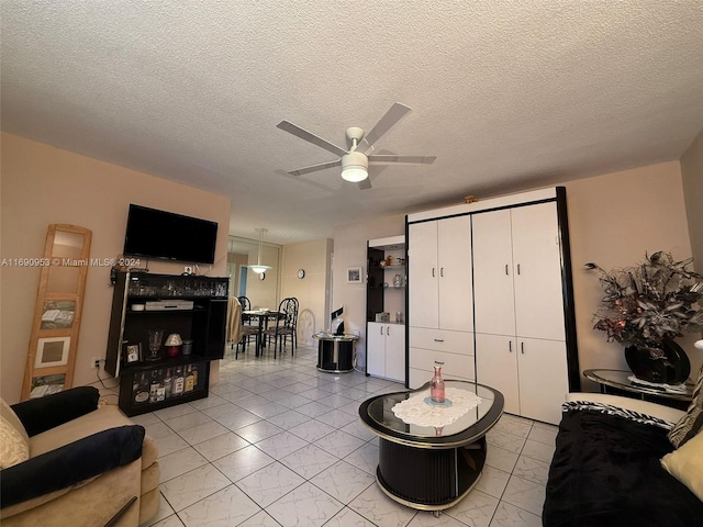 living room with a textured ceiling and ceiling fan