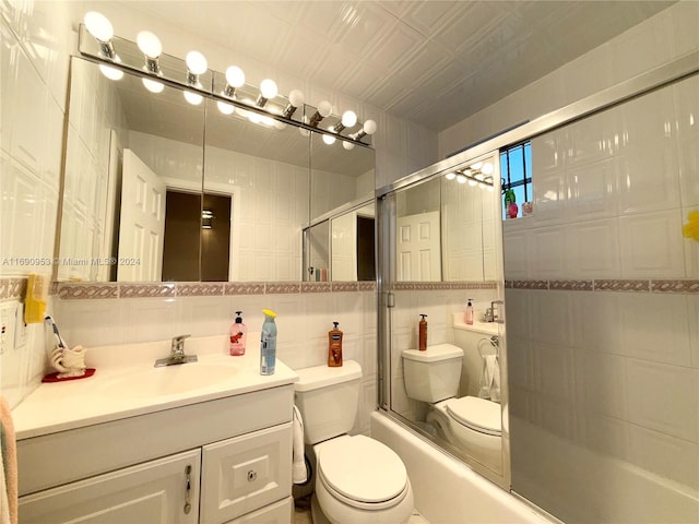 full bathroom with toilet, tile walls, bath / shower combo with glass door, vanity, and backsplash