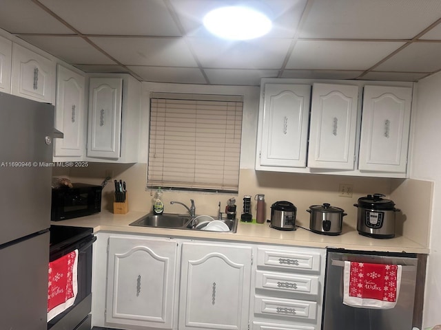 kitchen with sink, white cabinetry, a paneled ceiling, electric range, and stainless steel refrigerator