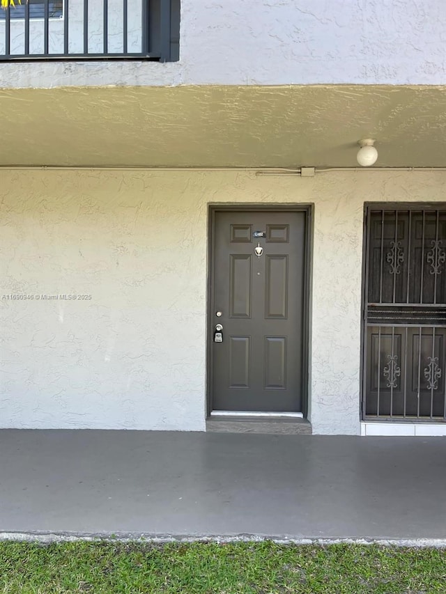 property entrance with stucco siding