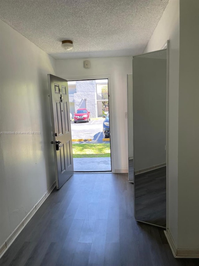 entrance foyer featuring baseboards, wood finished floors, and a textured ceiling