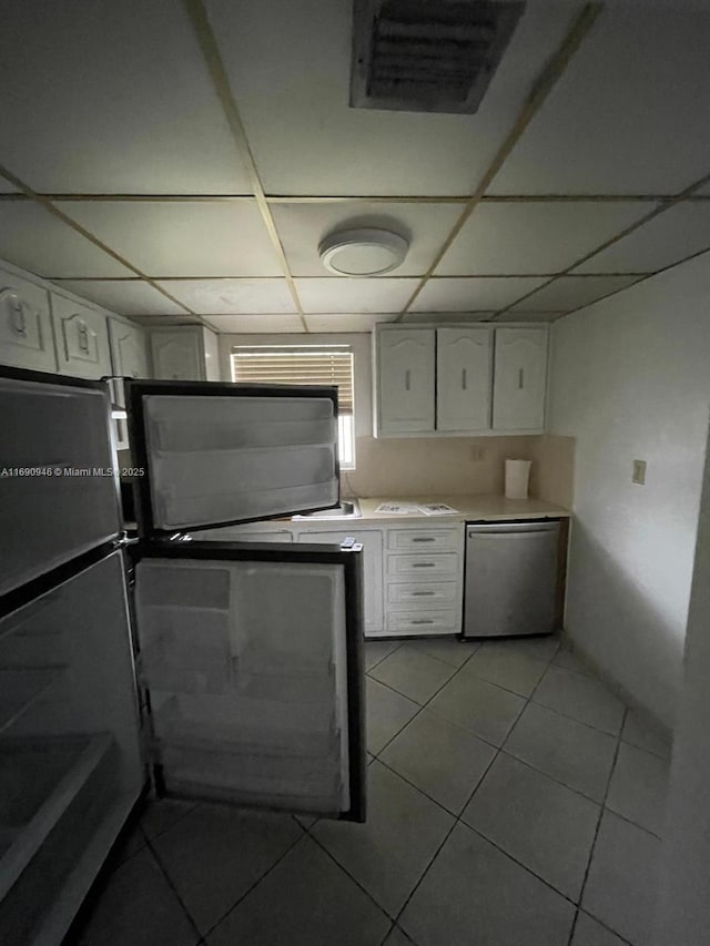 kitchen with light countertops, stainless steel dishwasher, visible vents, white cabinets, and a paneled ceiling