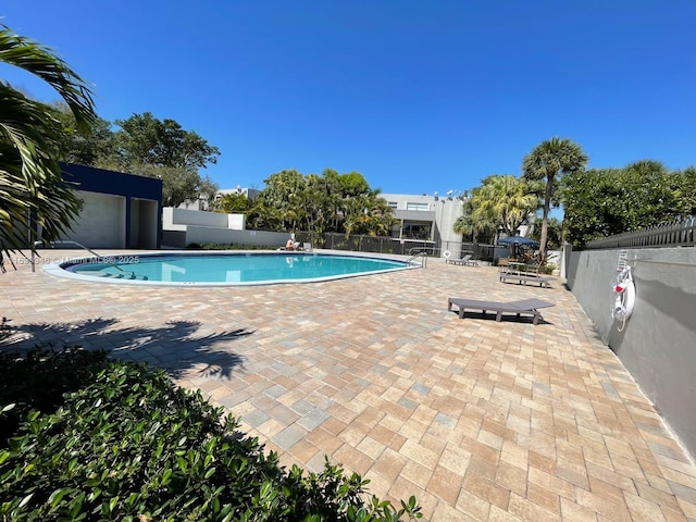 pool featuring fence and a patio area