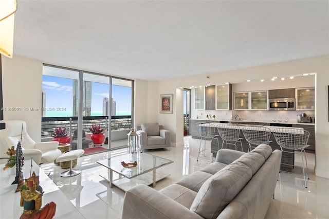 living room featuring expansive windows, light tile patterned floors, and sink