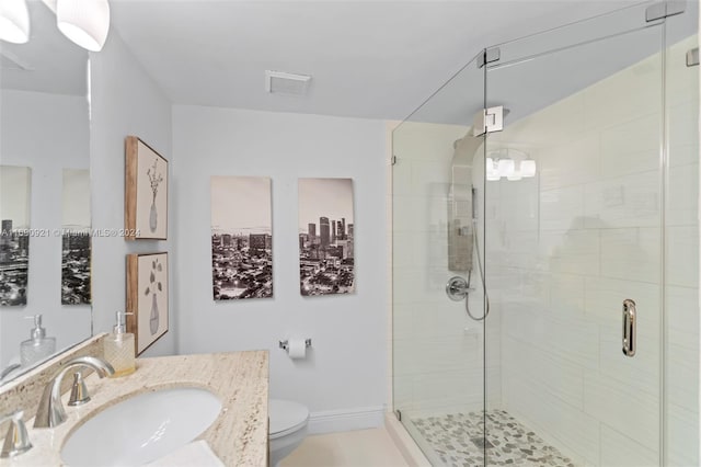 bathroom featuring toilet, vanity, tile patterned floors, and a shower with shower door