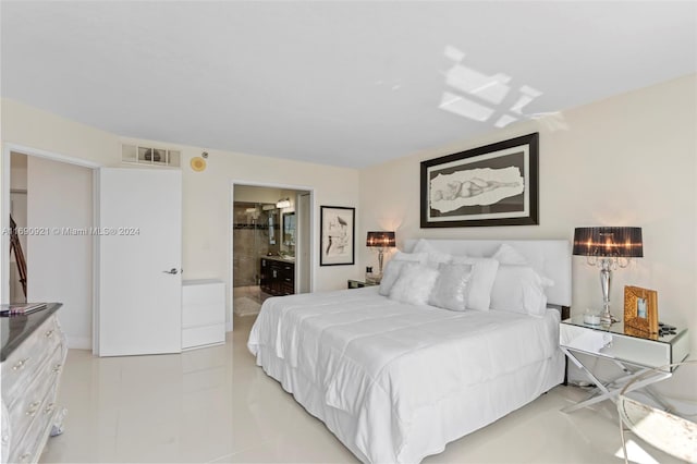 bedroom with light tile patterned flooring and ensuite bathroom