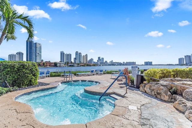 view of swimming pool featuring a water view and a patio area