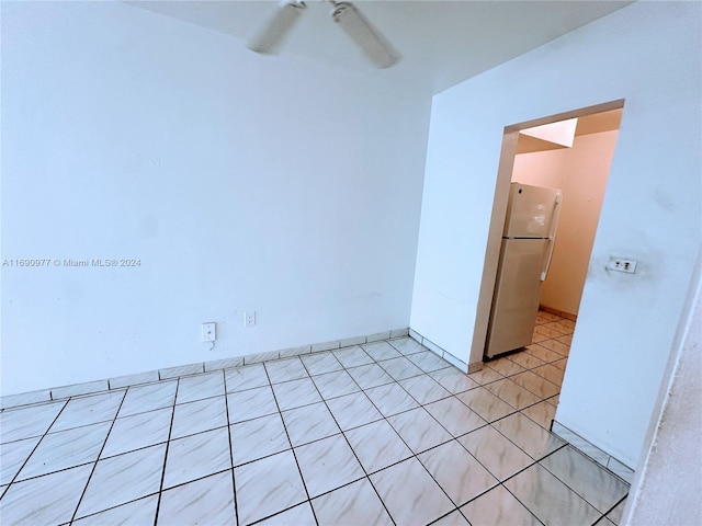 tiled empty room featuring ceiling fan