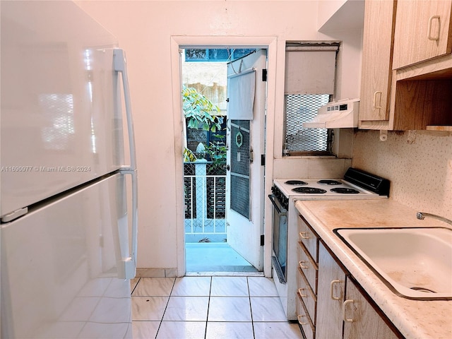 kitchen with sink, exhaust hood, backsplash, light brown cabinetry, and white appliances