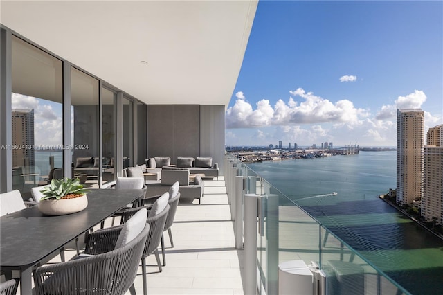 balcony with outdoor lounge area and a water view