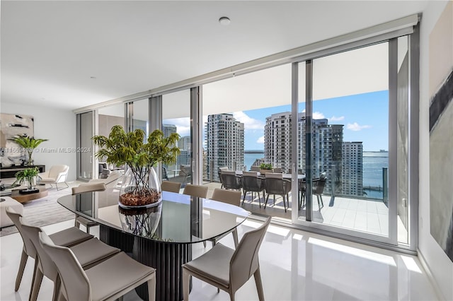 dining area with plenty of natural light, floor to ceiling windows, and a water view