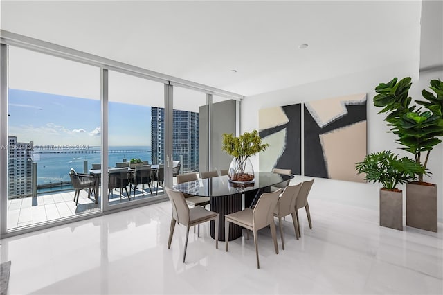 dining space with floor to ceiling windows and a water view