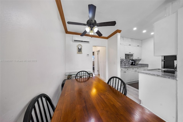 dining space featuring ceiling fan, ornamental molding, and a wall unit AC