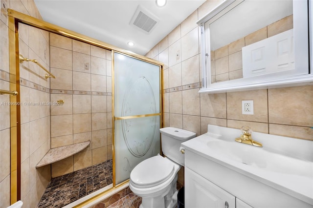 bathroom with tile walls, vanity, toilet, and walk in shower